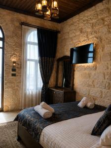a bedroom with a bed with a tv on the wall at Kasrı Hatun Konağı in Mardin