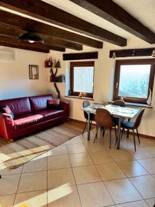 a living room with a red couch and a table at Belle vue des Alpes in Blavy