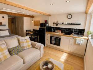 a living room with a couch and a kitchen at The Old Smithy in Trefriw