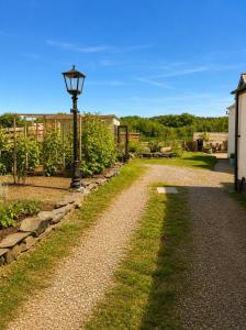 a street light next to a gravel road at The Old Smithy in Trefriw