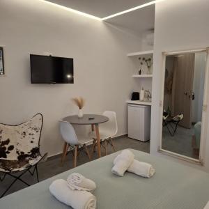 ein Schlafzimmer mit einem Bett und einem Tisch mit Stühlen in der Unterkunft Aetherian Suites in Loutra