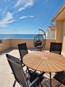 a table and chairs on a balcony with the ocean at Guesthouse Maro in Povljana