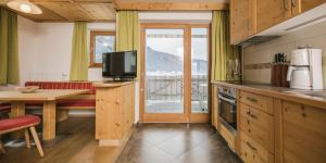a kitchen with a table and a television and a table at Pichlerhof in Valle Di Casies +45 photos