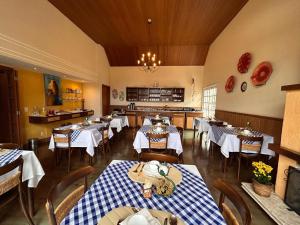a dining room with tables and chairs in a restaurant at Pousada Cheverny - Fácil acesso ao centrinho e Baden Bar Capivari in Campos do Jordão +43 photos