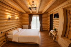 a bedroom with a bed in a wooden room at Casa Pădurarului in Câmpulung Moldovenesc