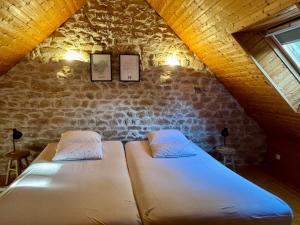 a bedroom with two beds in a attic at Le Gîte de Couturas in Saint-Hilaire-les-Courbes +43 photos