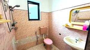 a bathroom with a pink toilet and a sink at Ayubo Villa in Ja-Ela