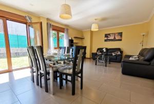 a dining room with a glass table and chairs at Casa Baixo O Castelo in Puente Caldelas