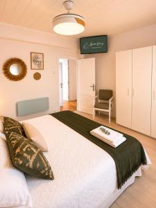 a bedroom with a large white bed and a chair at Abuela Maruja - Piso acogedor en Cee, perfecto para desconectar in Cee