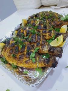 a fish sitting on top of tin foil with lemon slices at La tente in Tamaghzah