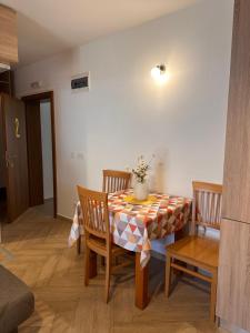a dining room table and chairs with a vase on it at Capri apartments in Kotor