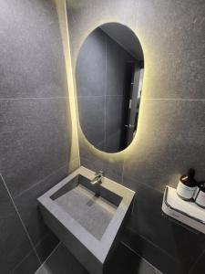 a bathroom with a sink and a round mirror at LUVO Signature Hotel in Seoul
