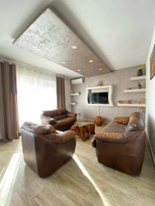 a living room with two leather chairs and a tv at Batica in Radanovići