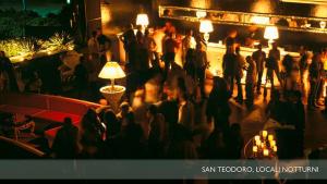 a crowd of people standing in a room with lights at Li Teggi Turismo Rurale in San Teodoro