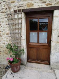 a door with a potted plant in front of a building at Le Tilleuil in Combiers