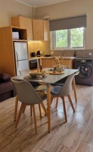a kitchen with a table and chairs in a kitchen at Marathon Studios & Apartments in Keri