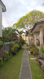 a garden with a row of houses and plants at Kirra's Beach House in Pulukan