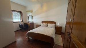 a bedroom with a bed and a desk and a window at Hotel Reels - Residencial O TRINDADE in Águeda