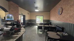 a restaurant with tables and chairs and a brick wall at Hotel Reels - Residencial O TRINDADE in Águeda