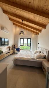 a bedroom with a large bed and a large window at צימר המשאלות בגלבוע in Nurit