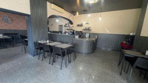 a restaurant with tables and chairs and a counter at Hotel Reels - Residencial O TRINDADE in Águeda