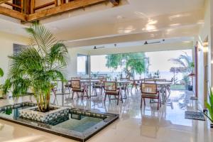 a dining room with tables and chairs and a potted plant at Mora Mila in Arugam Bay