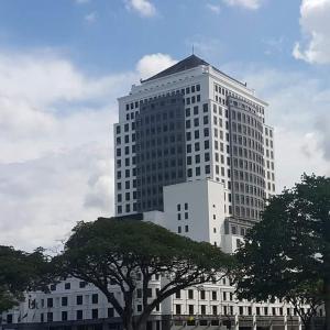 
a tall building with a clock on top at Merdeka Palace Hotel & Suites in Kuching
