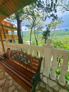 a wooden bench sitting on a porch with a fence at Gora Babilina in Gordi
