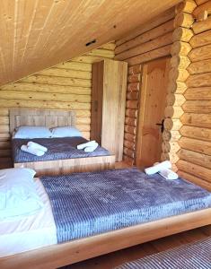 two beds in a log cabin bedroom at Gora Babilina in Gordi