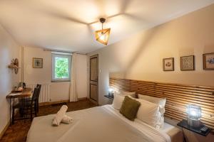 a bedroom with a bed and a desk and a window at la Ferme de Vazerat in Massiac
