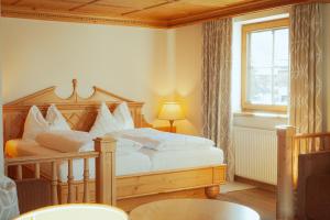 a bedroom with a bed with white pillows and a window at Hotel Zur Post in Alpbach