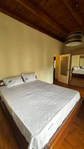a large white bed in a room with wooden floors at Panorea house in Polydrossos