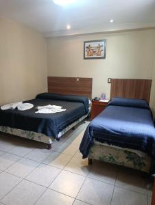 a bedroom with two beds and a table with a bedskirts at Hotel Ke Kuul in Salta