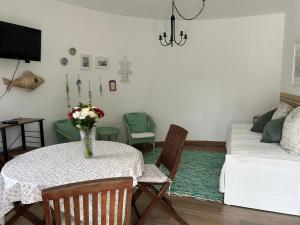 a living room with a table and a couch at Conjó - Golf & Beach Apartment Praia del Rey in Amoreira