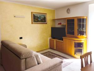 a living room with a couch and a flat screen tv at NicoMeli Home in Dimaro