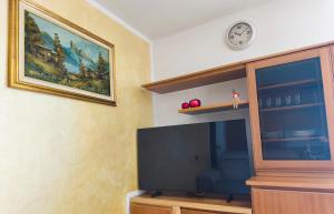 a living room with a tv and a clock on the wall at NicoMeli Home in Dimaro +22 photos