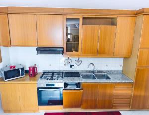 a kitchen with wooden cabinets and a stove top oven at NicoMeli Home in Dimaro