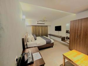 a hotel room with a bed and a television at Casa Sevara Hotel in Vagator