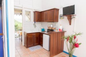 a kitchen with wooden cabinets and a white refrigerator at L'escapade in Sainte-Anne