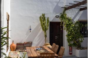 a wooden table with chairs and a cactus on a patio at Al 583 di Lindos in Lindos
