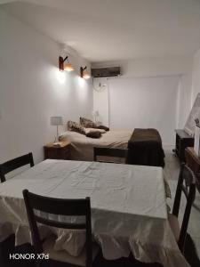 a room with two beds and a table and a couch at Mitre1349bis in Villa Basso