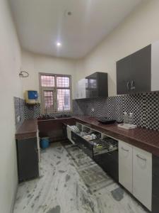 a large kitchen with a damaged counter top at Om Homestay in Panchkula