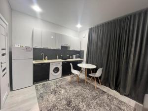 a kitchen with a table and chairs and a washer at APARTMENT CENTRAL zm in Edineţ