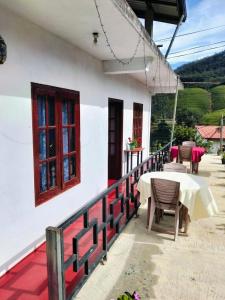 a table and chairs on a porch of a house at The Train View in Nuwara Eliya +55 photos
