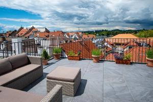 a patio with a couch and chairs on a balcony at Haus Spiegel - Cramergasse, Lindau Insel in Lindau