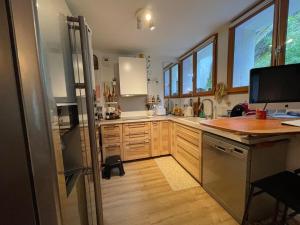 a large kitchen with wooden cabinets and a refrigerator at Montana Appartment in Planay