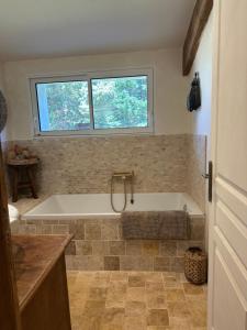 a bath tub in a bathroom with a window at chambre aux moutons in Saint-Méard-de-Gurçon +23 photos