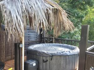 a hot tub sitting on a deck with a staircase at Cabanes rêve d'enfant in Les Anses-dʼArlets +2 photos