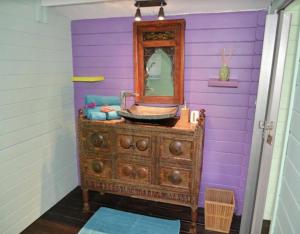 a bathroom with a sink and a mirror on a dresser at Cabanes rêve d'enfant in Les Anses-dʼArlets