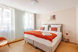 a bedroom with a large bed with orange and white pillows at Casa Rheinblick - Apartment B in Basel